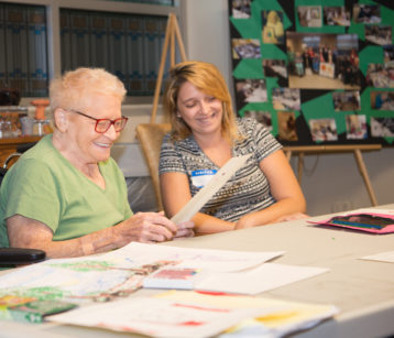 an older woman and a CMSS staff member with memory games for older adults