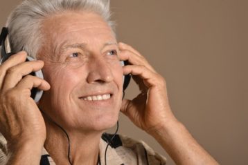 happy senior man listen music in headphones
