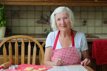 Happy grandmother preparing cookies in the kitchen