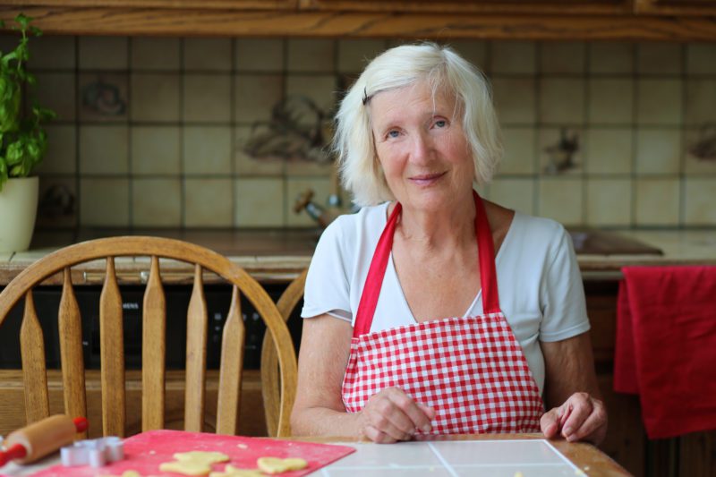 Happy grandmother preparing cookies in the kitchen