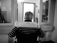 black and white photo showing the backside of a senior adult sitting in a wheelchair