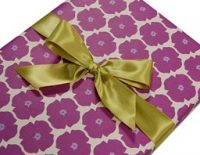a present wrapped in a purple floral pattern paper and a golden bow