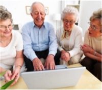 a group of senior adults look at a laptop