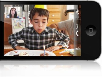 video chat on a phone screen. The primary image is of a boy blowing out birthday corners. In a small screen in the upper left corner, a woman watches this.