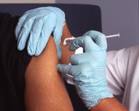 A medical professional administers a flu shot to a patient