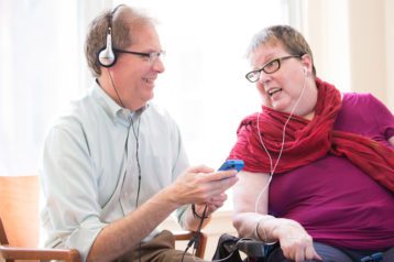 A woman listens to music on her headphones as part of a music therapy memory program